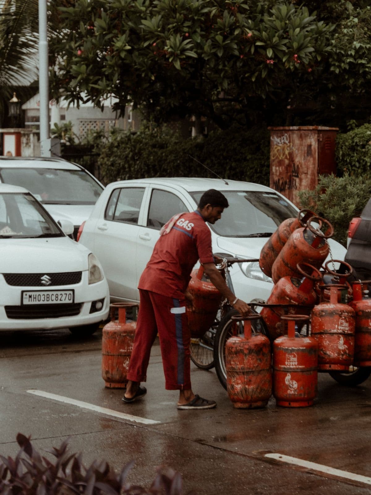 A delivery worker loading full gas cylinders onto a cart